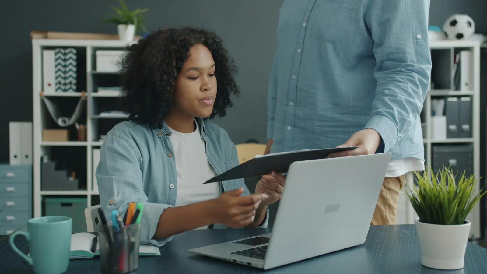 A business owner reviewing figures on a laptop with a colleague