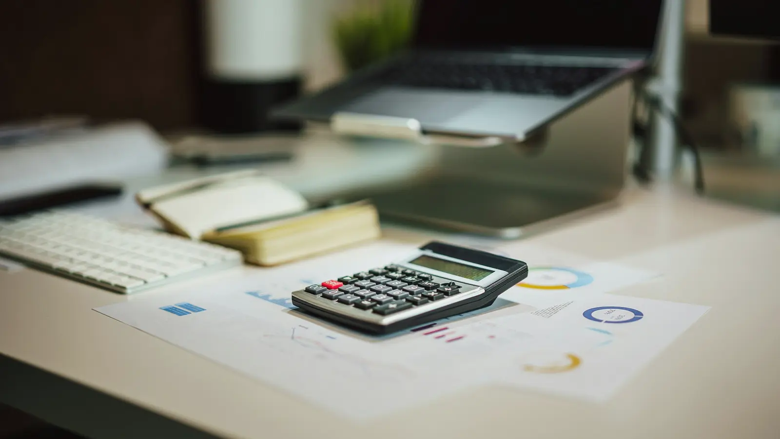 A calculator and financial reports on an office desk